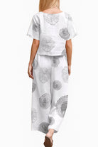 woman wearing Breezy Meadow two-piece set with relaxed top and wide-leg trousers outdoors