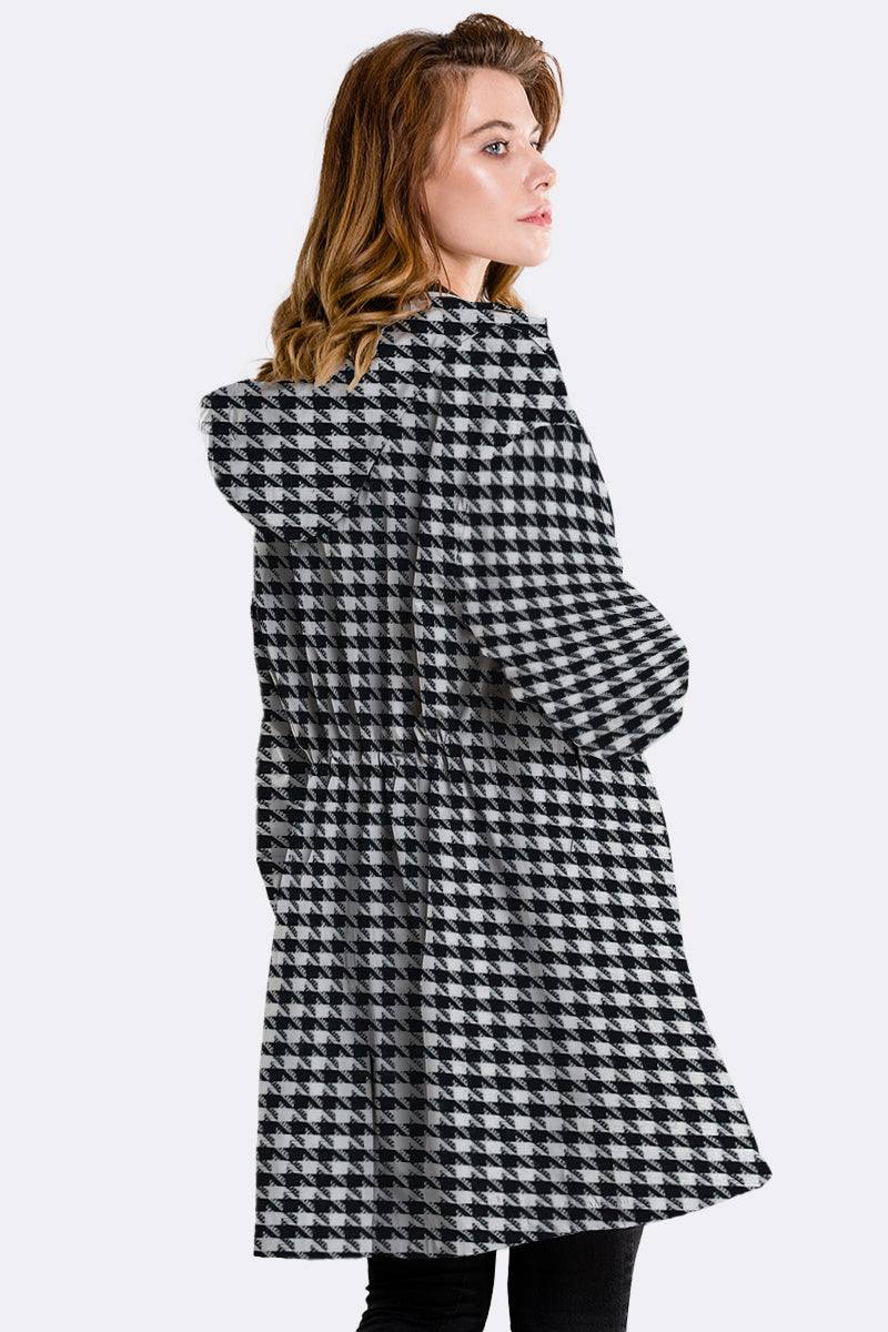 Woman wearing water-resistant oversized hooded windbreaker with black and white houndstooth pattern