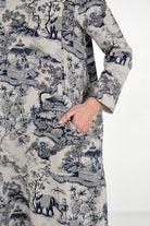 Close-up of Japanese porcelain print on beige-blue midi dress with 3/4 sleeves and functional pocket detail