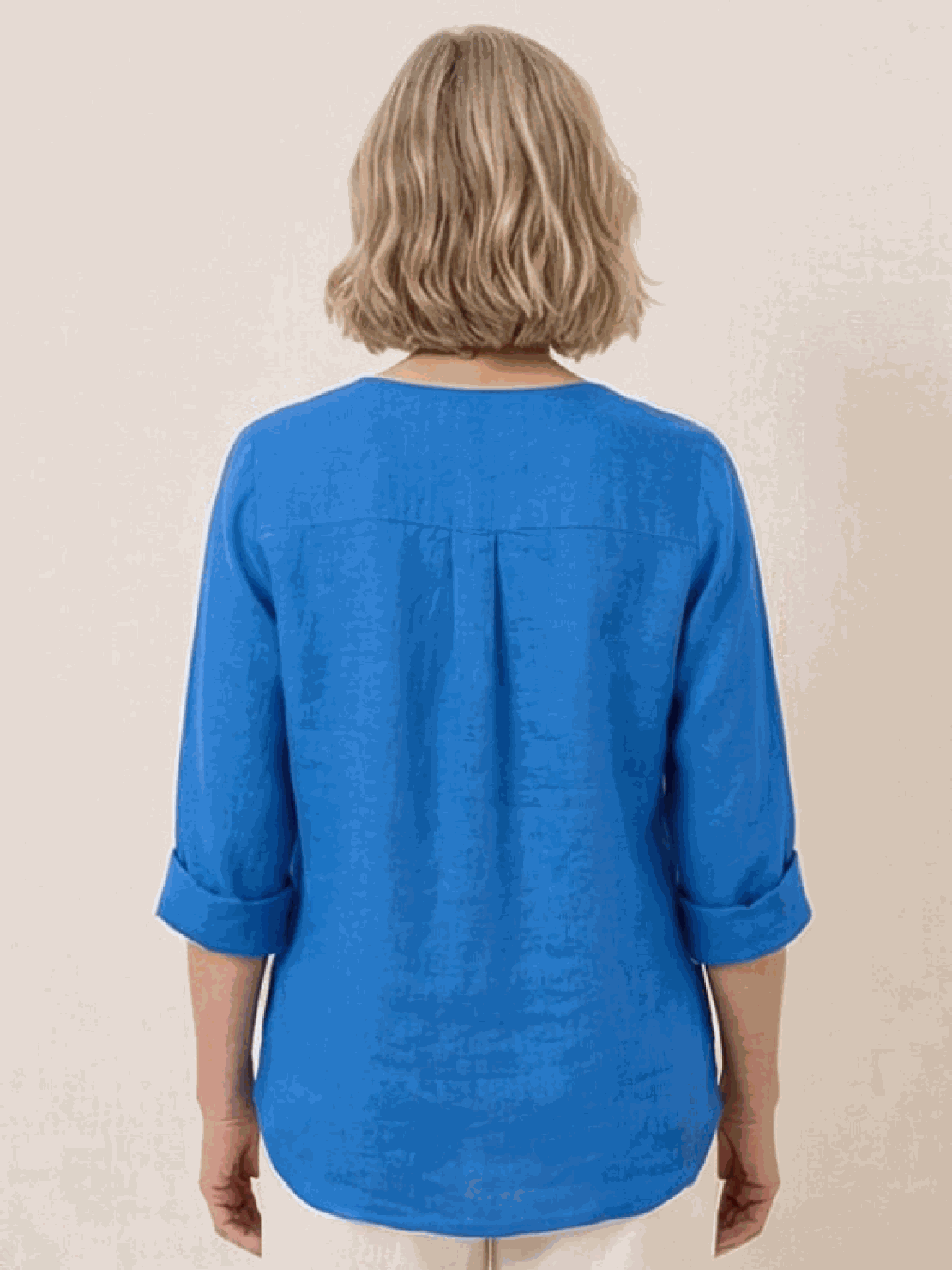 White pure linen age-defying shirt with button detail on hanger against white background