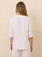 Back view of woman wearing a white Pure Linen Age-Defying Button Detail Shirt with rolled sleeves and relaxed fit.