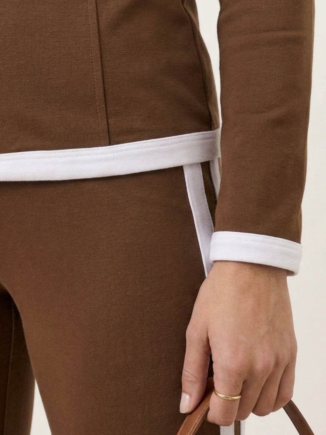Woman wearing sleek contrast zip two-piece outfit in neutral tones