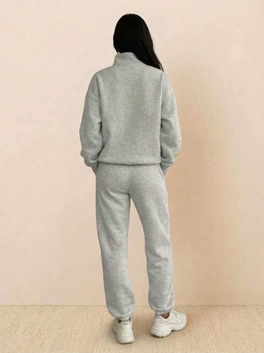 Woman wearing a cotton-blended two-piece tracksuit with high collar and deep zipper for casual, comfortable athleisure style