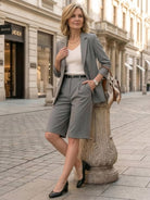 Woman wearing a polished blazer and high-waisted shorts two-piece set in a monochrome style
