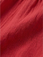 Woman wearing capped-sleeve voluminous pleated midi dress with flowing skirt and pockets