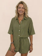 Woman wearing Coastal Linen Cotton two-piece set with button-down top and shorts in a natural setting