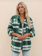 Woman wearing green and white checkered comfy flannel classic button-down shirt with rolled sleeves and light wash jeans