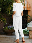 Woman wearing a relaxed fit cotton linen set with a short-sleeve top and straight-leg pants in monochrome tones