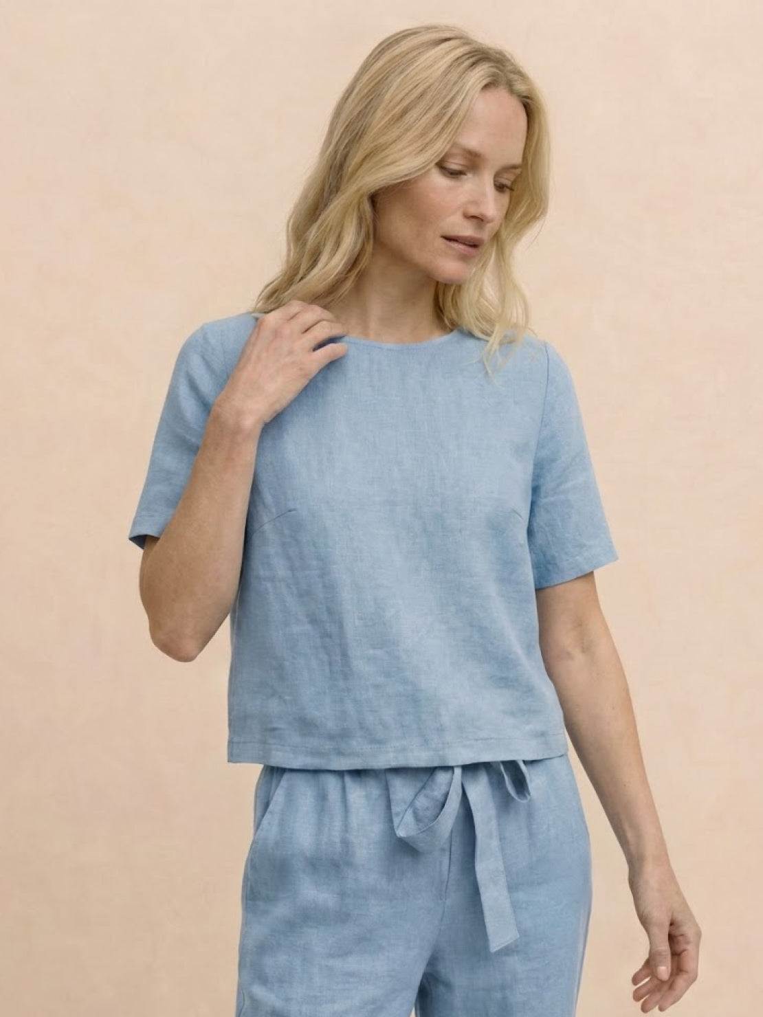 Woman wearing relaxed cotton linen set with short-sleeve top and straight-leg pants in monochrome tones