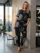 Woman wearing a relaxed cotton linen set with short-sleeve top and straight-leg pants in monochrome tones