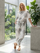 Woman wearing a breathable cotton linen set with relaxed short-sleeve top and straight-leg pants in monochrome tones