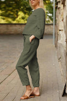 Woman wearing olive green cotton-linen monochrome relaxed longline top and wide-leg pants set outdoors
