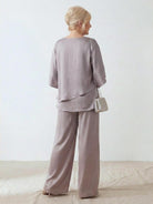 Woman wearing Elegant Layers Two-Piece Set with layered V-neck top and matching pants in light fabric