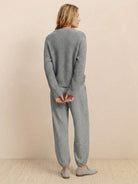 Woman wearing a relaxed grey knit sweater top and trouser set embodying European Minimalism style from the back.