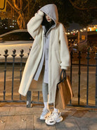 Woman wearing an oversized cozy sherpa-lined long coat with a hood, styled for everyday casual wear at night.