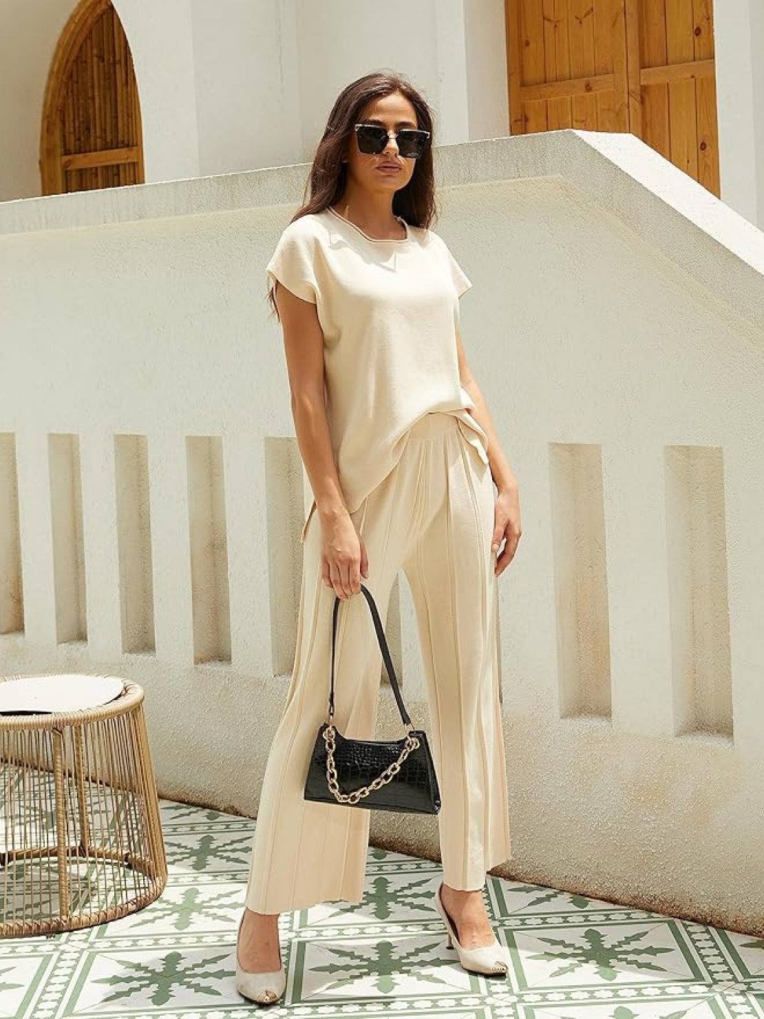 Woman wearing a wrinkle-resistant, pleated two-piece travel set made from breathable viscose-acrylic blend, embodying first class travel comfort and elegance