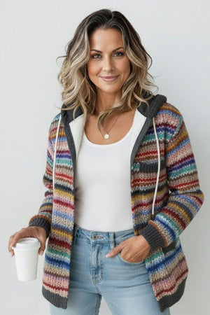Woman wearing colorful striped knit hoodie holding coffee cup, casual fall outerwear