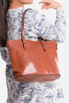 Brown PU leather multi strap tote shopper bag worn on shoulder with buckle details and spacious interior
