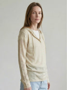 Organic linen henley top with fine knit, relaxed fit, long sleeves, and side slits in neutral heathered fabric