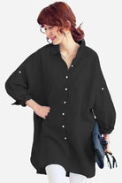 Woman wearing black oversized linen shirt with loose sleeves and button details