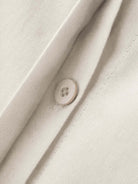 Close-up of oversized 100% cotton shirt fabric with button detail