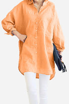 Woman wearing oversized orange linen shirt with long sleeves and white pants, holding black clutch bag