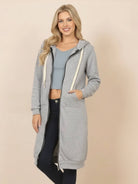 Woman wearing gray oversized long zip sweatshirt hoodie with drawstring hood and front pockets