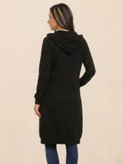 Back view of oversized long zip sweatshirt hoodie in black with hood and long sleeves worn by woman