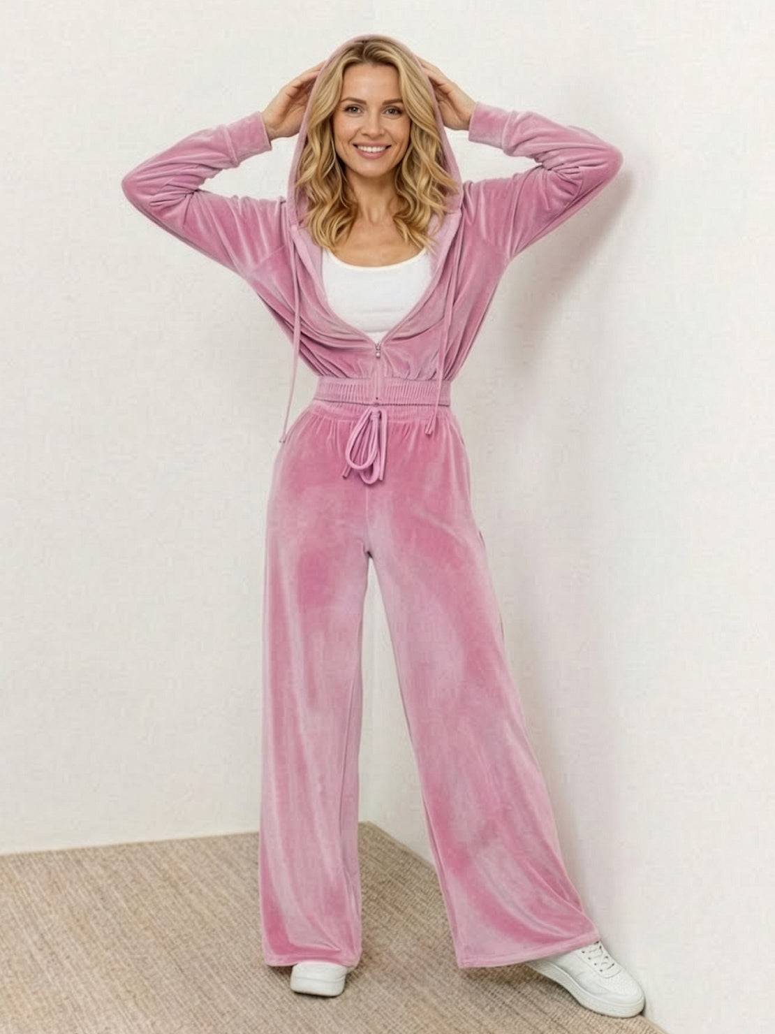 Woman wearing modern cropped velour tracksuit with high-waist pants in soft plush fabric