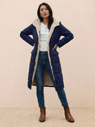Woman wearing navy Sherpa-lined hooded teddy coat with cozy sherpa interior and long silhouette outdoors