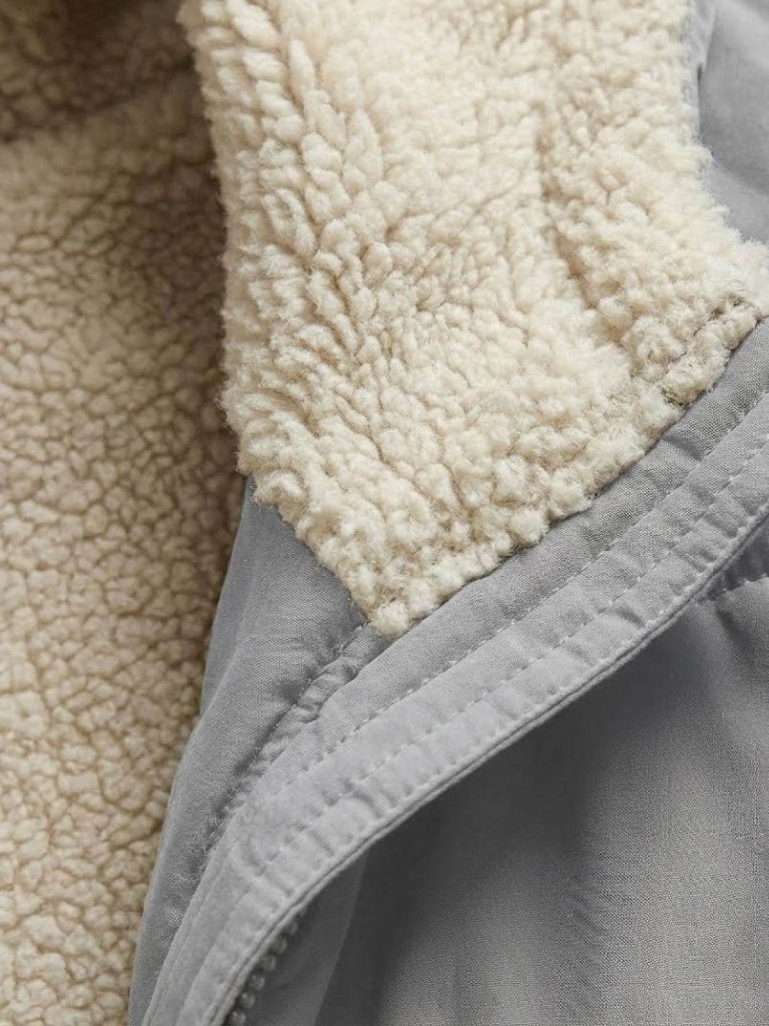 Close-up of sherpa lining and gray fabric on Sherpa-Lined Hooded Teddy Coat interior edge