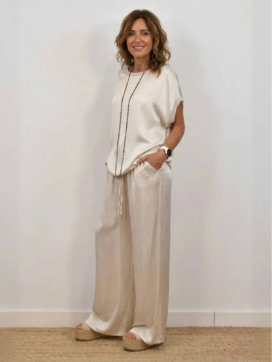 Woman wearing Silken Escape Satin Two-Piece Set with flowing satin fabric and wide-leg pants