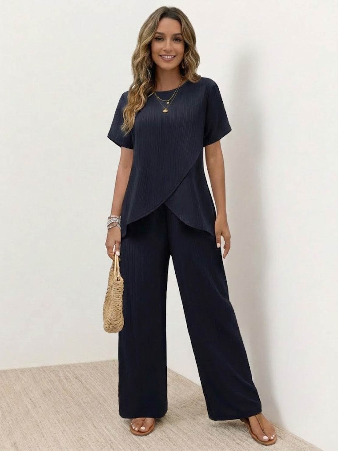 Woman wearing textured elegance two-piece set with asymmetrical top and wide-leg pants