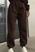 Brown cotton blend tracksuit pants with stretch waistband and cuffs paired with white sneakers, casual and comfortable athleisure wear