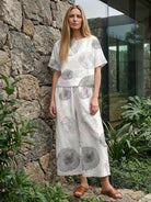 Woman wearing loose fit co-ord set with wide-leg trousers and short-sleeve top in soft floral print outdoors