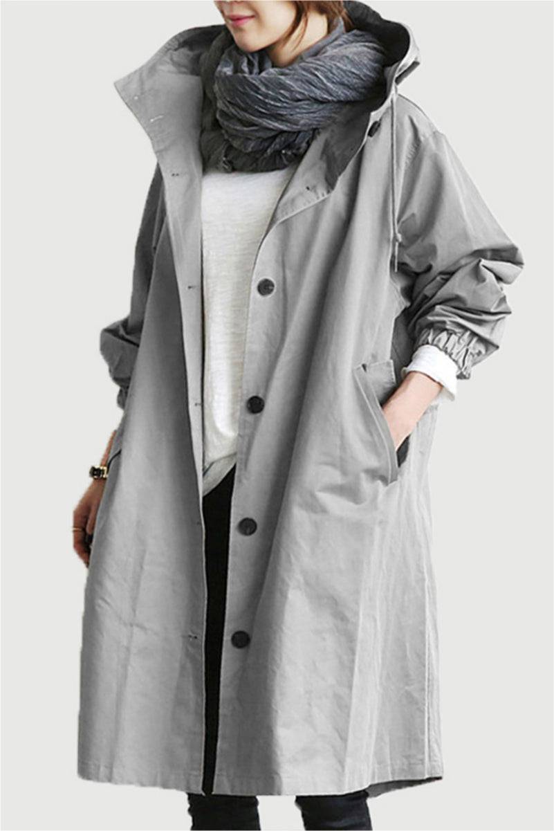 Gray oversized Rain Couture Windbreaker with hood and buttons, worn layered over casual outfit.