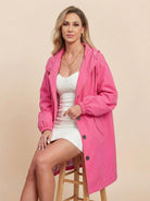 woman wearing pink oversized Rain Couture Windbreaker jacket sitting on wooden stool