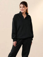 Woman wearing black ultra-soft and comfy co-ord tracksuit set with zip-up top and matching pants