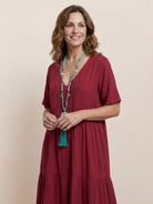 Woman wearing a V-neck two-tiered maxi swing dress with flowy tiers and irregular hemline in lightweight cotton fabric