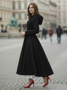 Woman wearing elegant water-repellent rain A-line hooded raincoat with belt outdoors